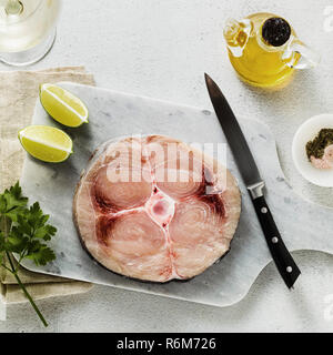 Rohen Schwertfisch Steak auf einem Marmor Schneidbrett mit Olivenöl und Gewürzen Stockfoto