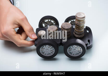 Hand, schwarz Warenkorb mit Stapel von Münzen Stockfoto