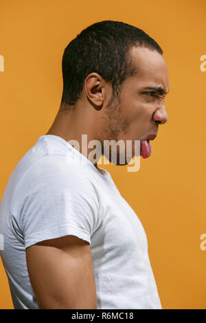 Crazy afro-amerikanischer Mann ist auf der Suche lustig gegen orange Hintergrund Stockfoto