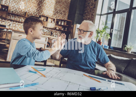 Gut aussehender grauhaariger Mann an seinem Enkel suchen Stockfoto