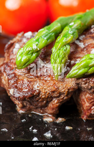 Rindersteak und grünem Spargel in einem Topf Stockfoto