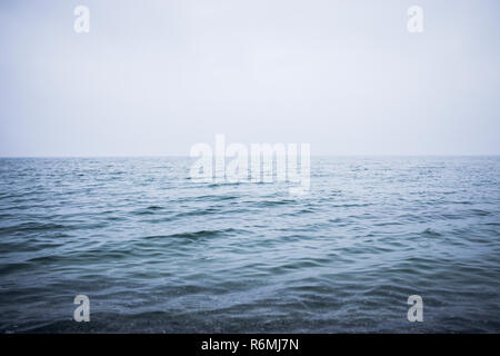 Saubere und ruhige blaue Meer oder Ozean. Nebel über der Wasseroberfläche. Bild mit Platz für Ihren Text. Stockfoto