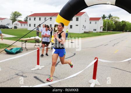 Sgt. 1. Klasse Renee Gaviland mit der 732. bekämpfen Sustainment Support Battalion der Wisconsin National Guard in Tomah überquert die Ziellinie in 5 k Run/2-Meile zu Fuß im Rumpel Fitness Center am 17. Mai 2017, als Teil von 2017 Fort McCoy Wellness Messe. Gaviland war der weiblichen Finisher in den Lauf in 22:57. Teilnehmer an der Messe nahmen nicht nur an laufen/gehen, sie besuchten auch Dutzende von Informations-Displays mit Produkten und Dienstleistungen von lokalen Firmen und Post-Agenturen. Das amerikanische Rote Kreuz auch eine Blutspendeaktion statt, und viele Tür Preise waren fair Teilnehmer gegeben. Die f Stockfoto