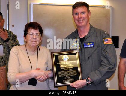 NAS Whidbey Island (25. Mai 2017) Naval Air Station (NAS) Langley befehlshabenden Offizier, Kapitän Geoffrey Moore legt Umweltbericht der base Program Director Melanie Bengtson mit dem Leiter der Marineoperationen Geschäftsjahr Environmental Award 2016 für die Erhaltung der natürlichen Ressourcen auf eine große Installation hier Mai 25. Dies ist die dritte große Environmental Award für die Abteilung ist die Grundlage für ihre Arbeit im Jahr 2016 vorgestellt. Weitere Auszeichnungen für 2016 gehören Sekretär der Marine Energie und Wasser Management Award für Top ufer Installation und Marine Community Service Umwelt Stewar Stockfoto