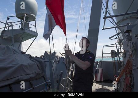 NAVAL STATION Rota, Spanien (29. Mai 2017) - Königlich Niederländische Marine Ensign Maarten Burger bringt eine Fahne an Bord der Arleigh-Burke-Klasse geführte Anti-raketen-Zerstörer USS Carney (DDG64) während der Abfahrt Naval Station Rota, Spanien, 29. Mai 2017. Carney, Vorwärts - nach Rota eingesetzt, ist die Durchführung der dritten Patrouille in den USA 6 Flotte Bereich der Maßnahmen zur Unterstützung der US-amerikanischen nationalen Sicherheitsinteressen in Europa. Stockfoto