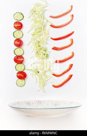 Der Salat Schüssel im Flug mit Gemüse: Tomaten, Gurken, Kohl auf weißem Hintergrund Stockfoto
