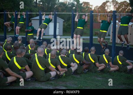 Bohrer Ausbilder mit Unterstützung Bataillon pullups, 26. Mai 2017 zu den Rekruten, die Echo Unternehmen zugewiesen wird, nachweisen, 2. rekrutieren Ausbildung Bataillon, auf Parris Island, S.C. Die anfängliche Stärke Test wird sichergestellt, dass die rekruten die minimalen körperlichen Anforderungen erfüllen, um die Ausbildung zu beginnen. Echo ist zu graduieren, Nov. 18, 2017 geplant. Stockfoto