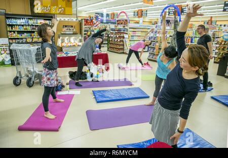 Mitglieder der Gemeinschaft beteiligen sich an einem Yogakurs in der gesunden Lebensweise event, 26. Mai 2017 in der OISO Family Housing Area Commissary. Stockfoto