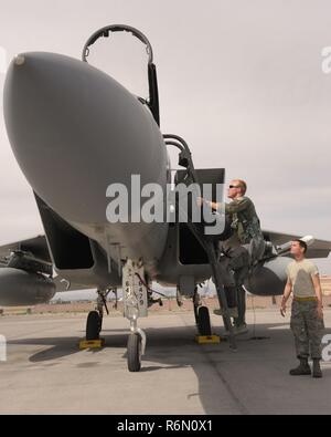 Oregon Air National Guard Kapitän Joshua Pfeifer, zu der 123 Fighter Squadron zugeordnet, Klettert eine Leiter an Bord eines F-15 Eagle, der 142 Fighter Wing zugeordnet, als Mannschaft Leiter Tech. Sgt. Ryan Johannes, bereitet Pfeifer mit seinem Flug auf der Nellis Air Force Base, Nev, 31. Mai 2017 zu unterstützen. Stockfoto