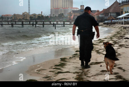 Escambia County Deputy Sheriff Patrick Frazier Spaziergänge entlang Pensacola Beach mit seinem Hund vor dem Hurrikan Ida, 9. November 2009 in Pensacola, Florida. Stockfoto