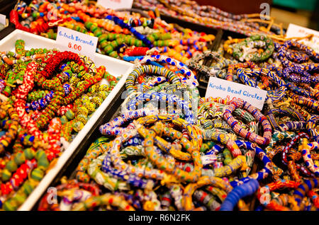 Afrikanische krobo bead Armbänder sind in Kästen auf der 34. jährlichen Mobile International Festival, Nov. 17, 2018 in Mobile, Alabama gestapelt. Stockfoto