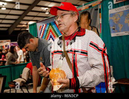 Amember der Poarch Creek Indianer Stamm, bespricht, Native American shell Carving am Mobile International Festival in Mobile, Alabama. Stockfoto