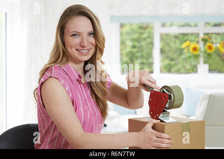 Portrait von Frau zu Hause Abdichtung Box für den Versand Stockfoto