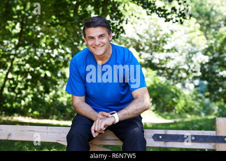 Portrait von reifer Mann mit Activity Tracker beim Training in der Landschaft Stockfoto