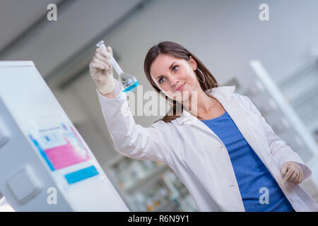 Junge, weibliche Forscher die Durchführung von Experimenten in einem Labor (flacher DOF Farbe getonte Bild) Stockfoto