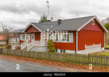 Auch, Schweden - 21. NOVEMBER 2018: typisch Schwedischen rot lackiertem Holz mit weißen Zierleisten freistehendes Haus oder Bungalow mit Keller Stockfoto