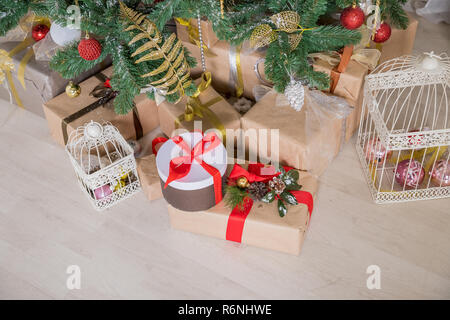 Geschenke und Geschenke unter dem Weihnachtsbaum, Winterurlaub Konzept. geschenkboxen in Handwerk Papier mit Satin rot Schleife für Weihnachtsgeschenk Box verpackt, Feier überraschen auf hölzernen Hintergrund, Kopieren, Grußkarte frame Stockfoto