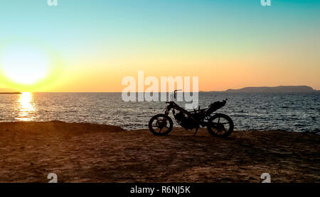 Verbrannt aufgegeben Motorrad am Strand Stockfoto