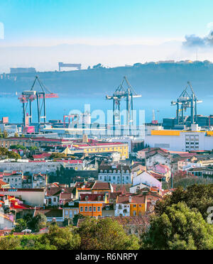 Skyline von Lissabon mit Fracht Krane und Cargo Container im Hafen durch den Fluss Tejo, Silhouette von Almada Bank auf Hintergrund Stockfoto