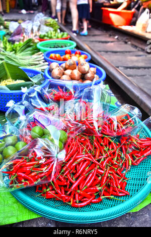 Verkauf von Speisen auf der Maeklong Railway Markt in Thailand Stockfoto