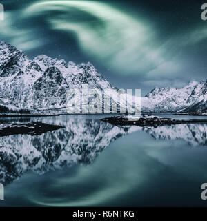 Nordlicht, Aurora borealis in Lofoten Inseln, Norwegen. Tolle Nacht Winterlandschaft mit Polar Lights und Sternenhimmel über die Bergkette Stockfoto