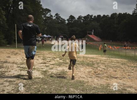 Aidan Flippo, Pilot für einen Tag Kandidat, Sprints auf dem Weg zur Ziellinie mit seinem Vater Staff Sgt. Dustin Flippo, Eglin Air Force Base Ehrengarde noncomissioned Offizier, während eine Nächstenliebe Schlamm - 20. Mai 2017, in Niceville, Florida. Flippo ausgewählt wurde Pilot die 33 Fighter Wing für einen Tag zu sein. Aidan war mit septo Optic Dysplasia, welche Auswirkungen seine Augen und Nieren geboren. Während seiner Tag, traf er F-35 Piloten, tourte ein Flugzeug, arbeitete mit dem Flugzeug Maintainer und vieles mehr. Stockfoto