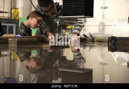 Us Air Force Staff Sgt. Nathaniel Ensing, 33 Aircraft Maintenance Squadron, zeigt Aidan Flippo, Pilot für einen Tag Kandidat, ein Stück Metall, 25. Mai 2017 geschnitzt wurde, in Eglin Air Force Base in Florida. Flippo ausgewählt wurde Pilot die 33 Fighter Wing für einen Tag zu sein. Aidan war mit septo Optic Dysplasia, welche Auswirkungen seine Augen und Nieren geboren. Während seiner Tag, traf er F-35 Piloten, tourte ein Flugzeug, arbeitete mit dem Flugzeug Maintainer und vieles mehr. Stockfoto