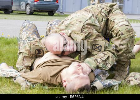 Kapitän Tschad Merfeld, APA-C, einen Flug Chirurgen mit 3-10 Allgemeine Unterstützung Aviation Battalion, 10 Combat Aviation Brigade, nahm an einem notfallvorsorge Bohren mit Mitgliedern des Lettischen Nationalen Streitkräften und der lettischen Luftwaffe am 19. Mai in Lielvarde, Lettland. Der Drill begann mit Brandmeldeanlagen und Rauch Maschinen im Betriebsgebäude und mit simulierten Unfall und Evakuierungen außerhalb gipfelte. Stockfoto