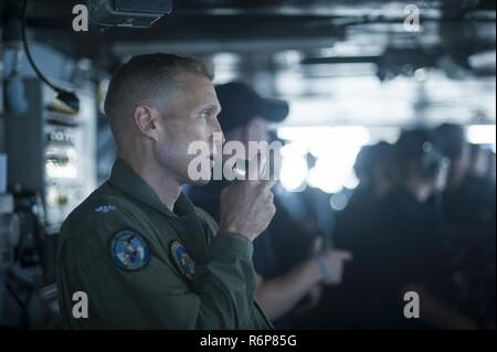 NORFOLK, Virginia (25. Juli 2017) die USS Harry S. Truman (CVN 75) Executive Officer, Capt. Cassidy Norman, liefert zu einer letzten Vorbereitungstagung Rede über das Schiff 1-MC vor zu ziehen, in den Hafen einzulaufen. Truman zurück zu Naval Station Norfolk nach dem erfolgreichen Abschluss eines 4-tag meer Studien Evolution. Stockfoto