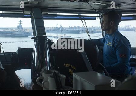 NORFOLK, Virginia (25. Juli 2017) die USS Harry S. Truman (CVN 75) kommandierenden Offizier, Kapitän Ryan B. Scholl, Peers an der Schiffe am Naval Station Norfolk während des Schiffes Transit in den Hafen. Truman zurück zu Naval Station Norfolk nach dem erfolgreichen Abschluss eines 4-tag meer Studien Evolution. Stockfoto