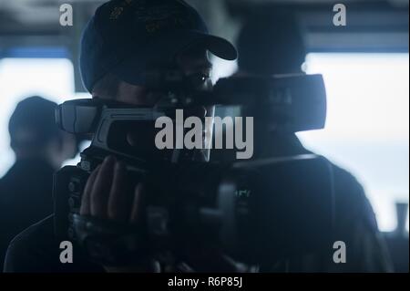 NORFOLK, Virginia (25. Juli 2017) Mass Communication Specialist 3. Klasse Zachary Van Nuys schießt Video auf der Brücke der USS Harry S. Truman (CVN 75) als das Schiff in den Hafen Transite. Truman zurück zu Naval Station Norfolk nach dem erfolgreichen Abschluss eines 4-tag meer Studien Evolution. Stockfoto