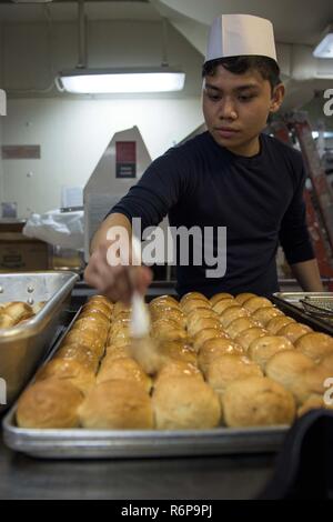 YOKOSUKA, Japan (31. 25, 2017) Kulinarische Specialist 2. Klasse Eugenemart Darlucio, von Carson City, Nevada, Butter Abendessen Brötchen in der Bäckerei an Bord der Marine vorwärts - bereitgestellt Flugzeugträger USS Ronald Reagan (CVN 76), während ein Urlaub Mahlzeit. Ronald Reagan, das Flaggschiff der Carrier Strike Group 5, bietet eine Bekämpfung bereit, Kraft, schützt und verteidigt die kollektive maritime Interessen seiner Verbündeten und Partnern in der Indo-Asia-Pazifik-Region. Stockfoto