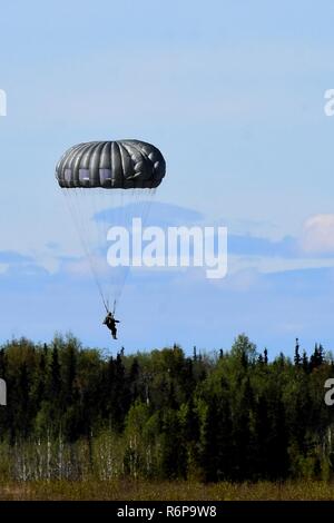 Ein Fallschirmjäger der US-Armee Alaska 4 Infantry Brigade Combat Team (Airborne), 25 Infanterie Abteilung springt von einer UH-60 Black Hawk Hubschrauber auf die malemute Drop Zone am Joint Base Elmendorf-Richardson, Alaska, am 16. Mai 2017. Stockfoto