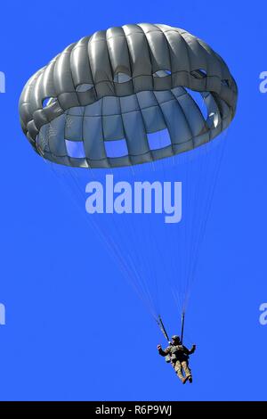 Ein Fallschirmjäger der US-Armee Alaska 4 Infantry Brigade Combat Team (Airborne), 25 Infanterie Abteilung springt von einer UH-60 Black Hawk Hubschrauber auf die malemute Drop Zone am Joint Base Elmendorf-Richardson, Alaska, am 16. Mai 2017. Stockfoto