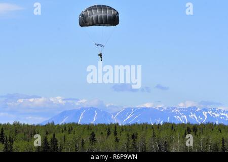 Ein Fallschirmjäger der US-Armee Alaska 4 Infantry Brigade Combat Team (Airborne), 25 Infanterie Abteilung springt von einer UH-60 Black Hawk Hubschrauber auf die malemute Drop Zone am Joint Base Elmendorf-Richardson, Alaska, am 16. Mai 2017. Stockfoto