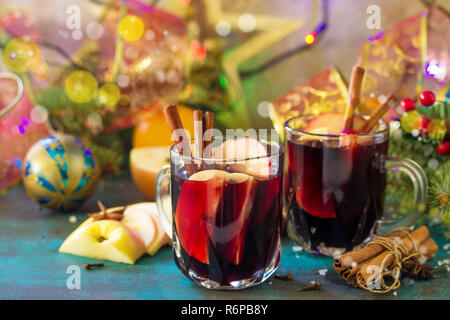 Weihnachten Glühwein oder Sangria mit Gewürzen. Zwei Gläser mit heißem Glühwein mit Apple und Gewürzen auf blau Schiefer Tisch. Stockfoto