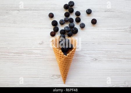 Süße Waffel Eiswaffel mit Blaubeeren auf weißem Holz- Oberfläche, Ansicht von oben. Flach, Overhead, von oben. Stockfoto