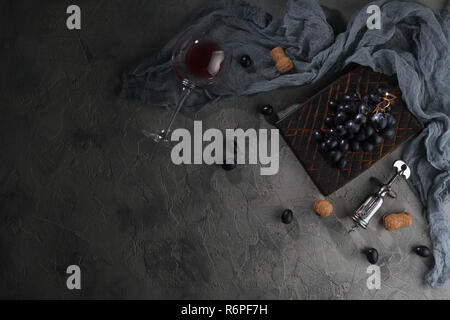 Rotwein in ein Glas Becher liegen auf einem grauen Hintergrund. Ansicht von oben mit Platz für Text. Stockfoto