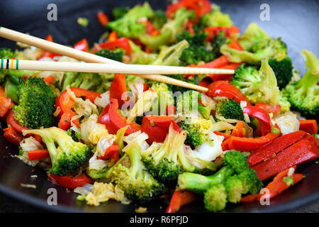 Wok mit Gemüse und Essstäbchen Stockfoto