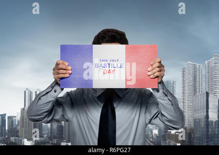 Geschäftsmann holding Flagge Frankreich mit Bastille Tag Text Stockfoto