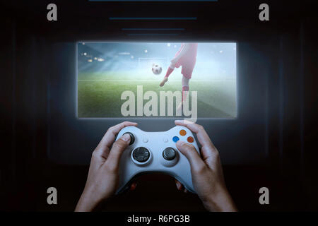 Hände mit Game Controller spielen Fußball-Spiel Stockfoto