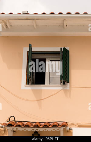 Grünen Jalousien geöffneten Fenster auf eine beige Wand. Stockfoto