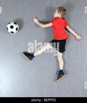 Junge von oben spielen Fußball Stockfoto