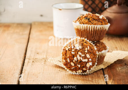 Karottenkuchen Muffins mit Nüssen, Rosinen und Hafer auf einer hölzernen Hintergrund. Im rustikalen Stil. Stockfoto