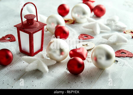 Weihnachtsdekoration mit Flitter Sterne und Rote Laterne auf einem weißen Versilbert Tisch. Stockfoto