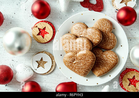 Bunter Teller mit hausgemachten Lebkuchen star Kugeln auf eine versilberte Tabelle. Stockfoto