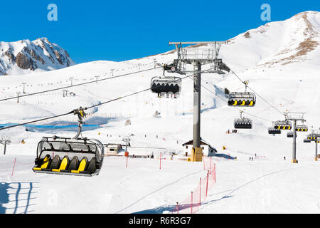 Skifahrer gehen Auf dem Sessellift gegen strahlend blauen Himmel - Ski Resort in Italien an sonnigen Wintertag Stockfoto