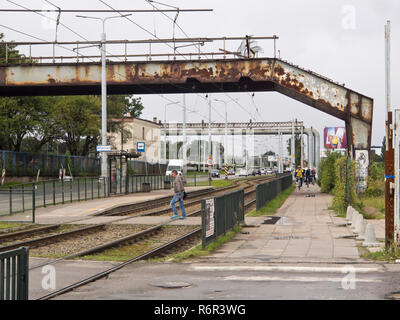 Rusty verstorbene Fußgänger-Überführung, Straßenbahnschienen, Gasleitungen, Bürgersteig in der Jana Z Kolna Straße in der Nähe der Alten Werft in Danzig, Polen Stockfoto