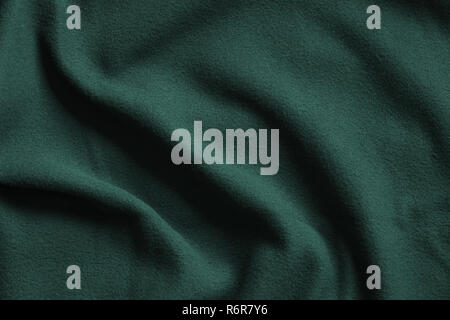 Textur von Dunkelgrün Fleece, weich Genoppt isolierenden Gewebe aus Polyester, wellenförmige Muster Stockfoto