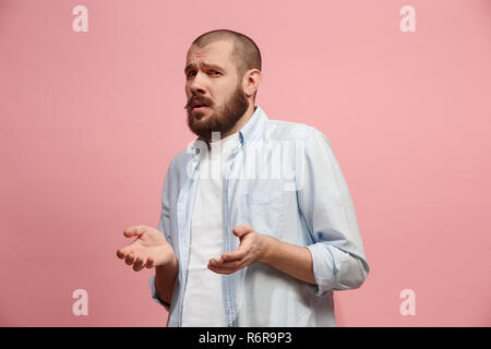 Lass mich nachdenken. Zweifelnd nachdenklicher Mann mit nachdenklichen Ausdruck die Wahl gegen rosa Hintergrund Stockfoto